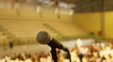 Microphone against blurry background of a crowd.