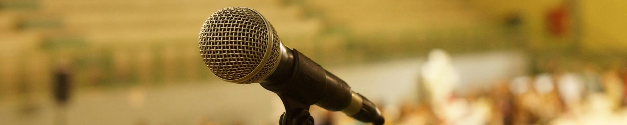 Microphone against blurry background of a crowd.